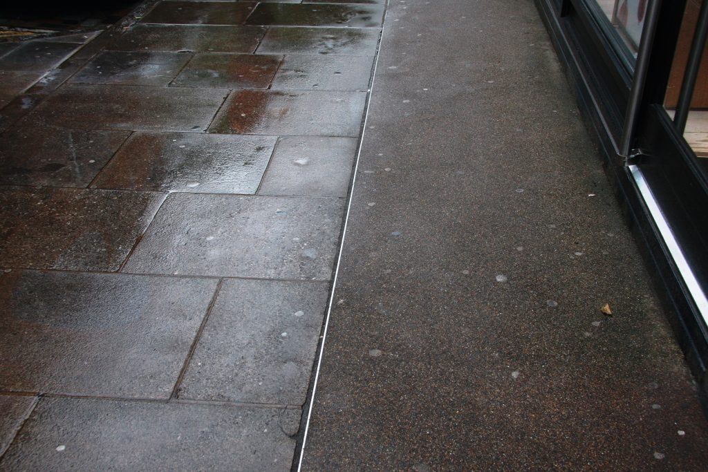 Photograph of limestone paving and warm-coloured dressed asphalt to seal vaults