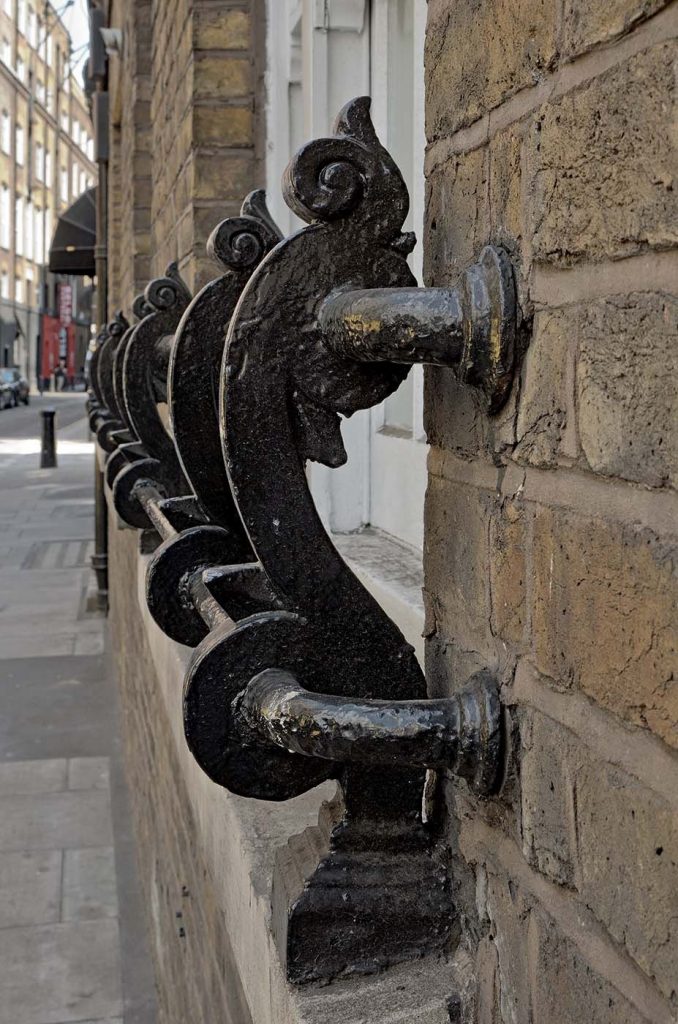close-up of Victorian ironwork windowbox supports painted black