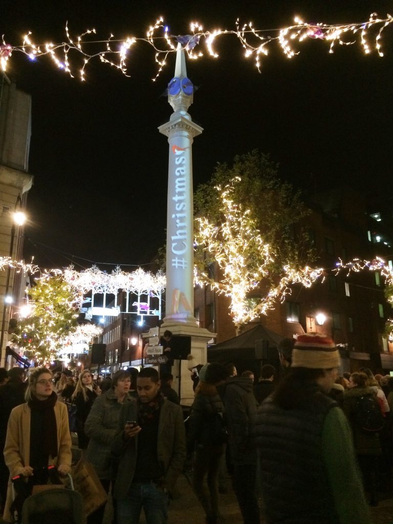 Sundial Pillar at night with Happy Christmas projection and Christmas lights.