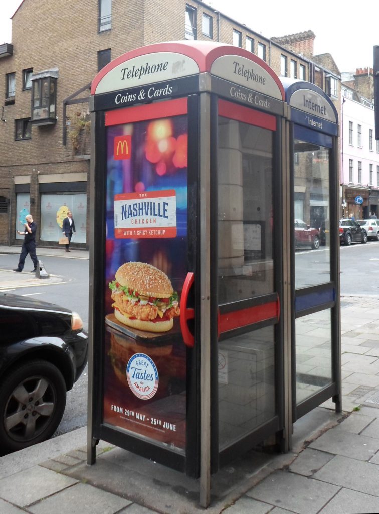 Modern public phone booth primarily used as advertising space